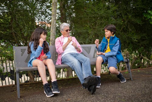 Children and an Elderly Man Sitting on a Bench