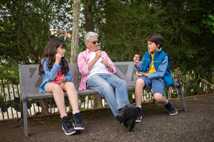 Children And An Elderly Man Sitting On A Bench