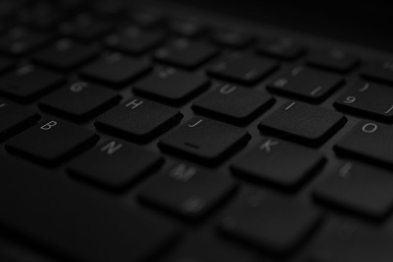 Close-up of a black laptop keyboard under soft ambient lighting