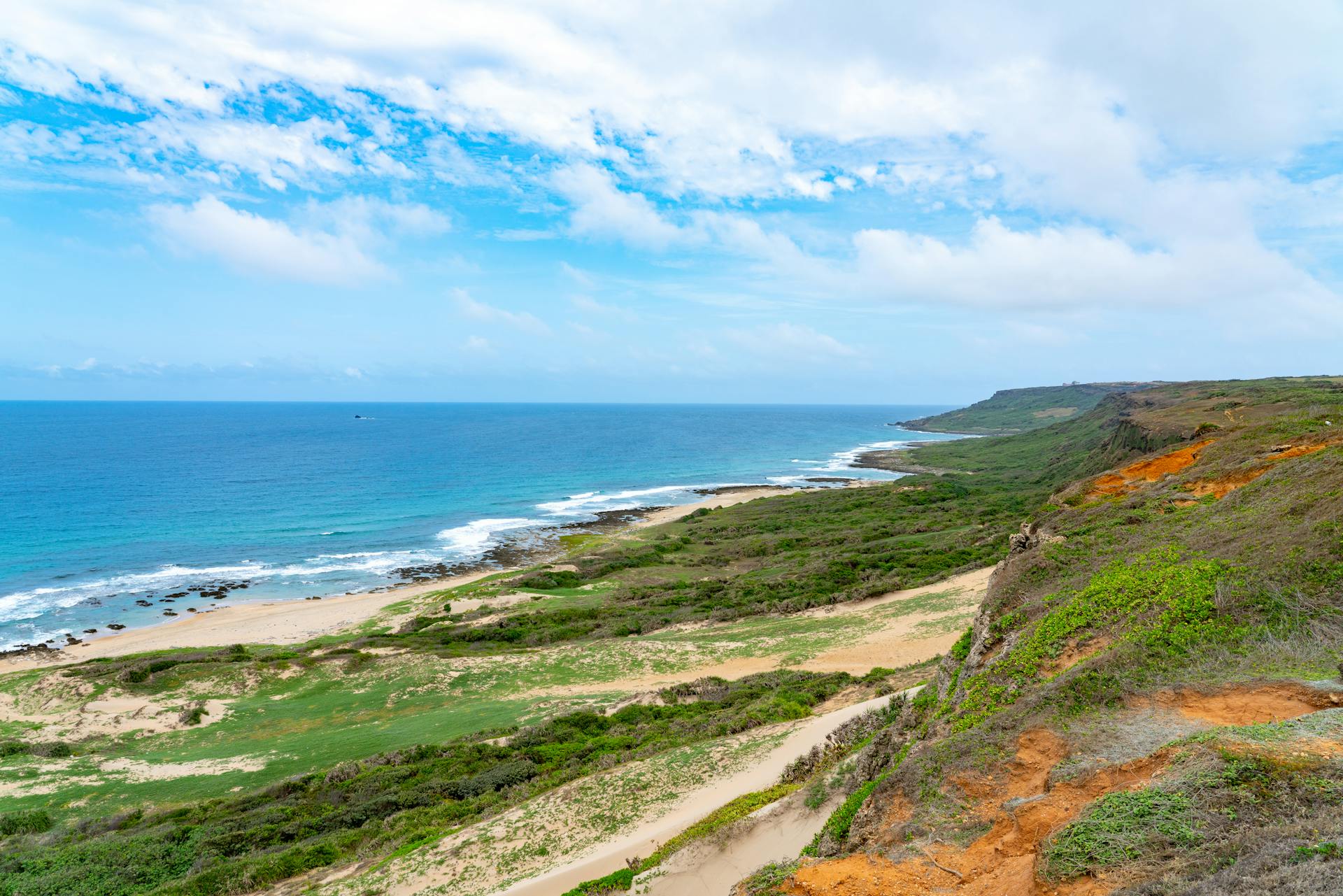 Breathtaking scenic view of the coastline at Kenting National Park, Taiwan with clear blue skies and lush greenery.