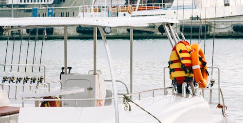Фотография белой лодки со спасательным жилетом на боку