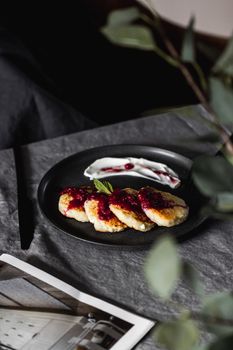 Delicious breakfast pancakes topped with berry sauce and cream, perfect for a cozy morning.