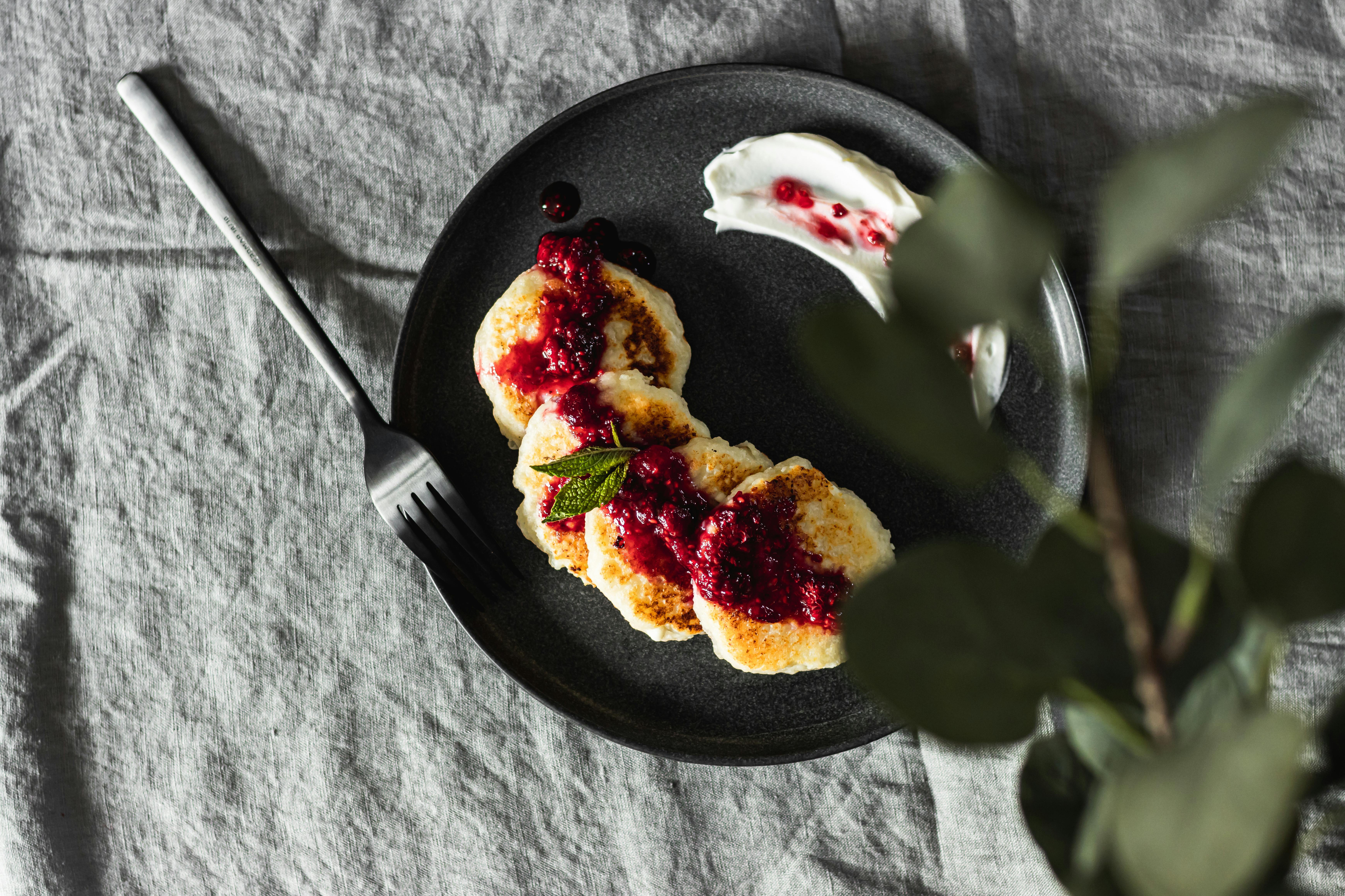 Cooking banana sour cream pancakes with diced bananas in skillet