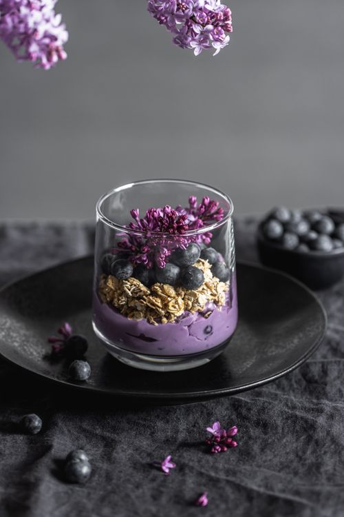 Free A stylish vertical shot of a blueberry granola parfait with lilac flowers. Stock Photo