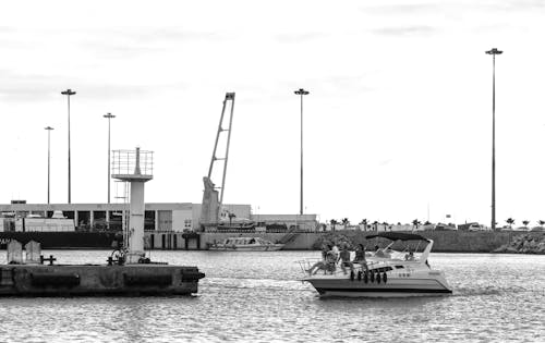 Grayscale Photo of People Riding on Yacht