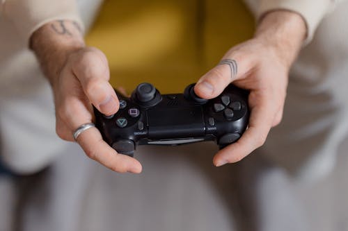 Free Person Holding a Black Game Controller Stock Photo