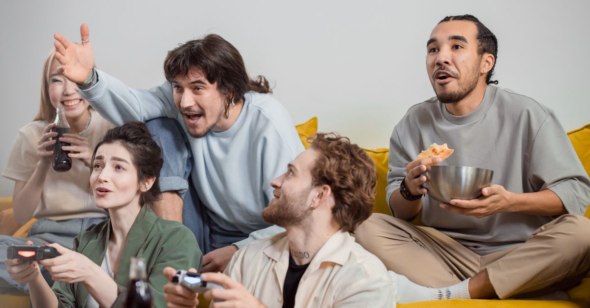 Friends Spiling Friends Playing Together on a Game Console · Free Stock Photo