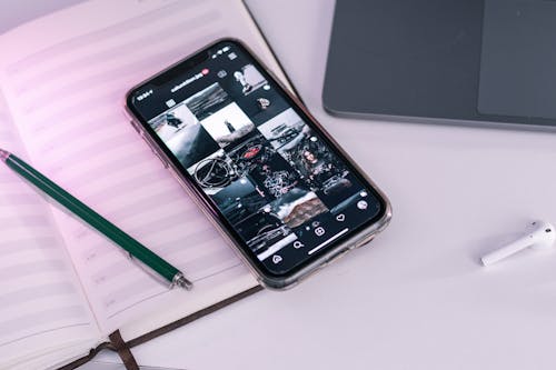 Close-Up Photo of a Mobile Phone beside a Pen