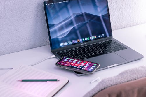 Free Modern laptop and smartphone near opened notepad for studies Stock Photo