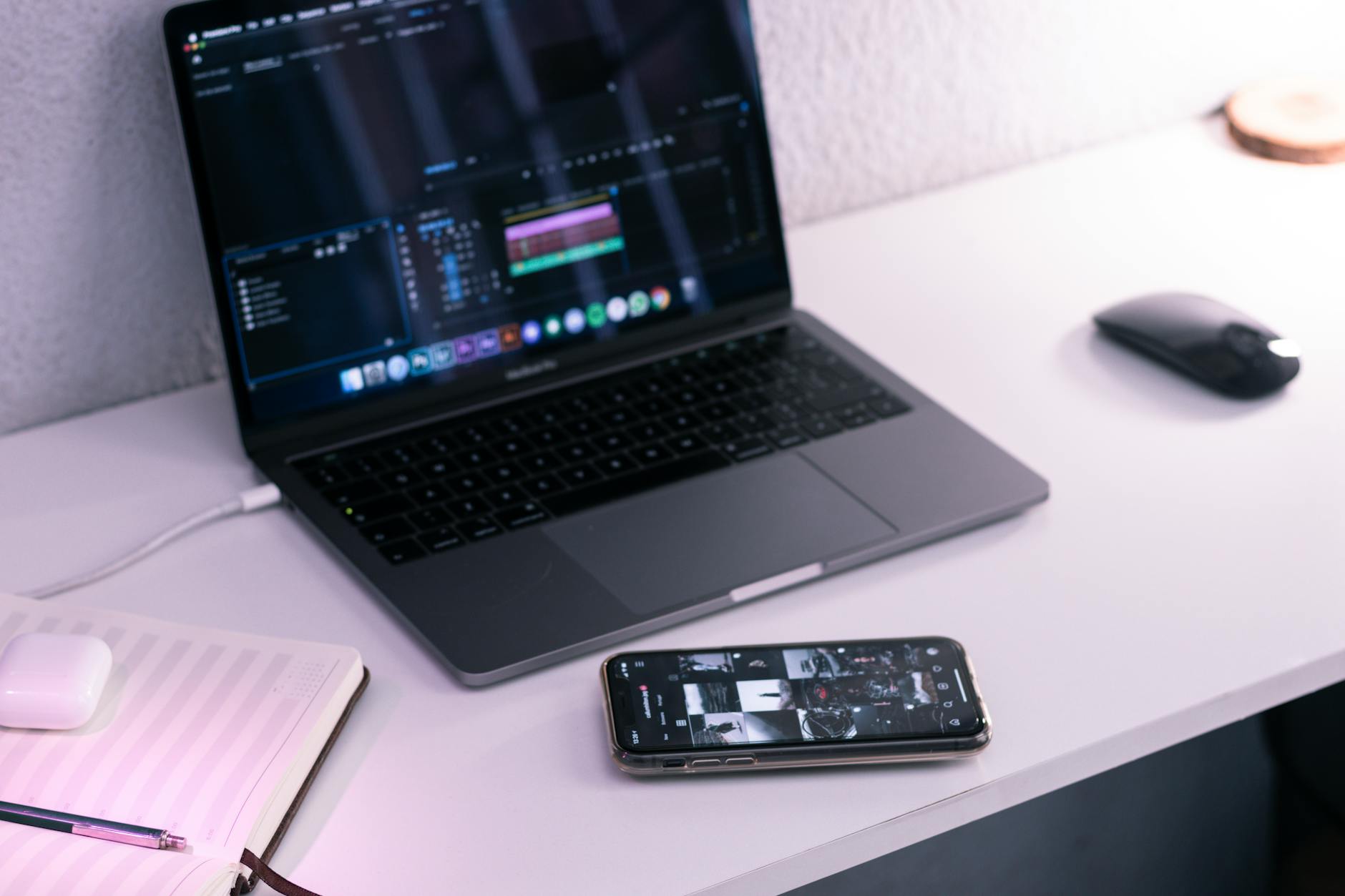 Smartphone with laptop and notebook on table