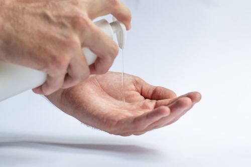 Free Crop anonymous male pouring antibacterial soap sanitizer for preventing spread of diseases and avoid infections Stock Photo