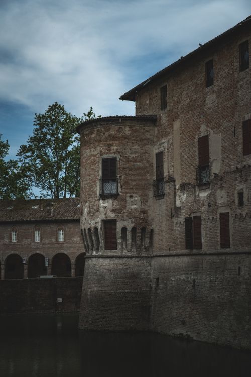 Free Exterior of aged stone gray abandoned house located near canal under blue cloudy sky Stock Photo