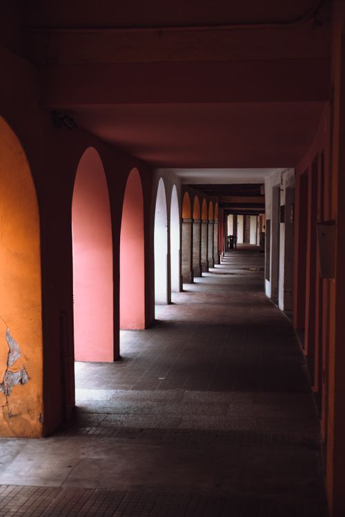 Free Empty narrow corridor between aged stone wall and arched shabby passages in old abandoned building Stock Photo