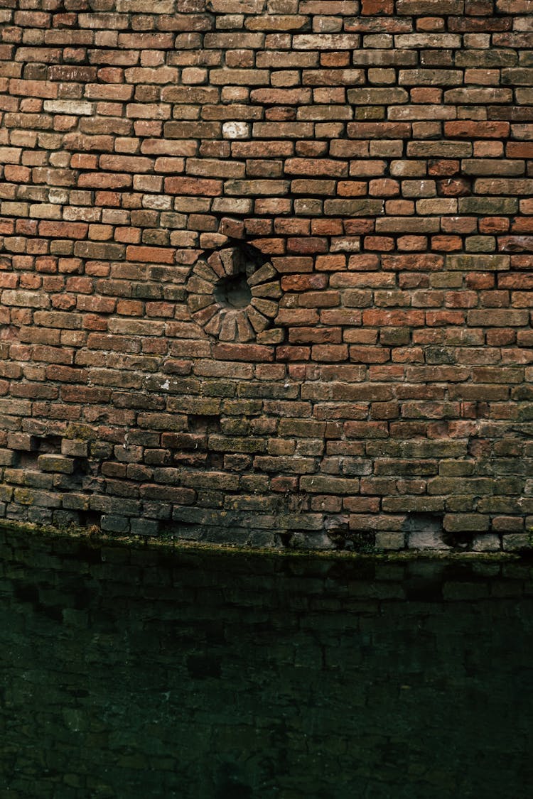 Old Stone Brick Wall Of Building Near Water