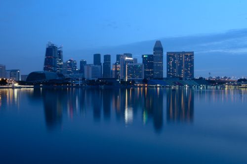 Free Beautiful evening view of Singapore skyline with reflections on the water, showcasing urban architecture. Stock Photo