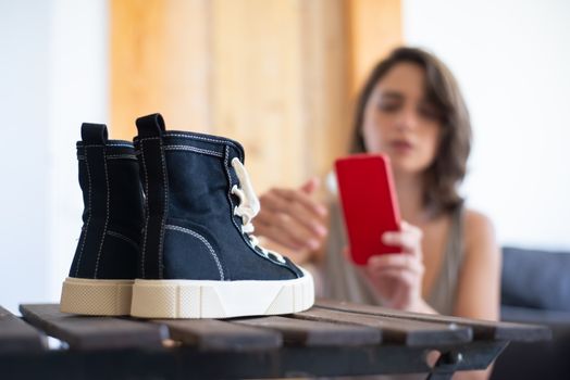 Close-up of sneakers with a woman taking pictures for an online store.