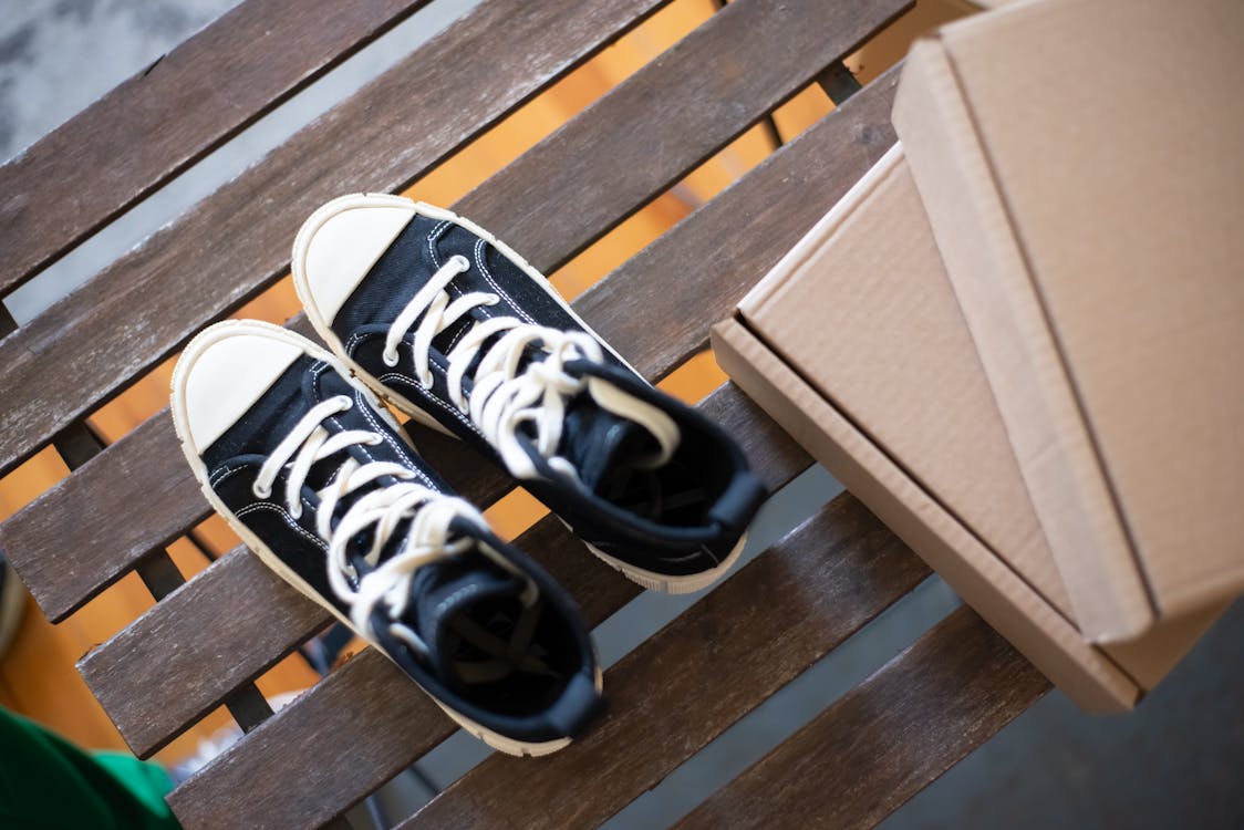 Hightops and Boxes on a Wooden Bench · Free Stock Photo