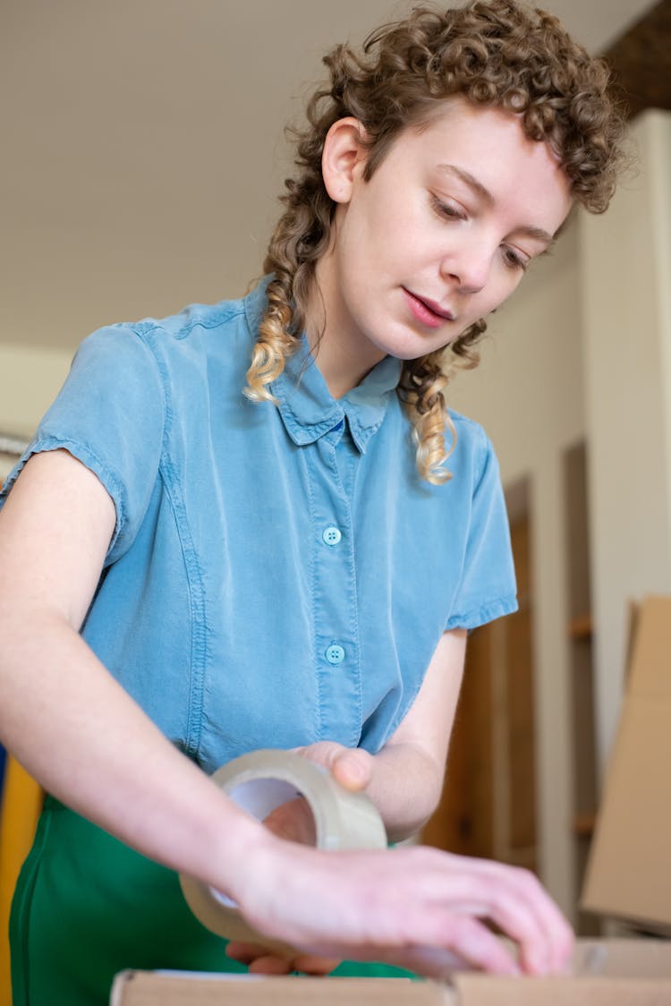 A Girl Taping A Box