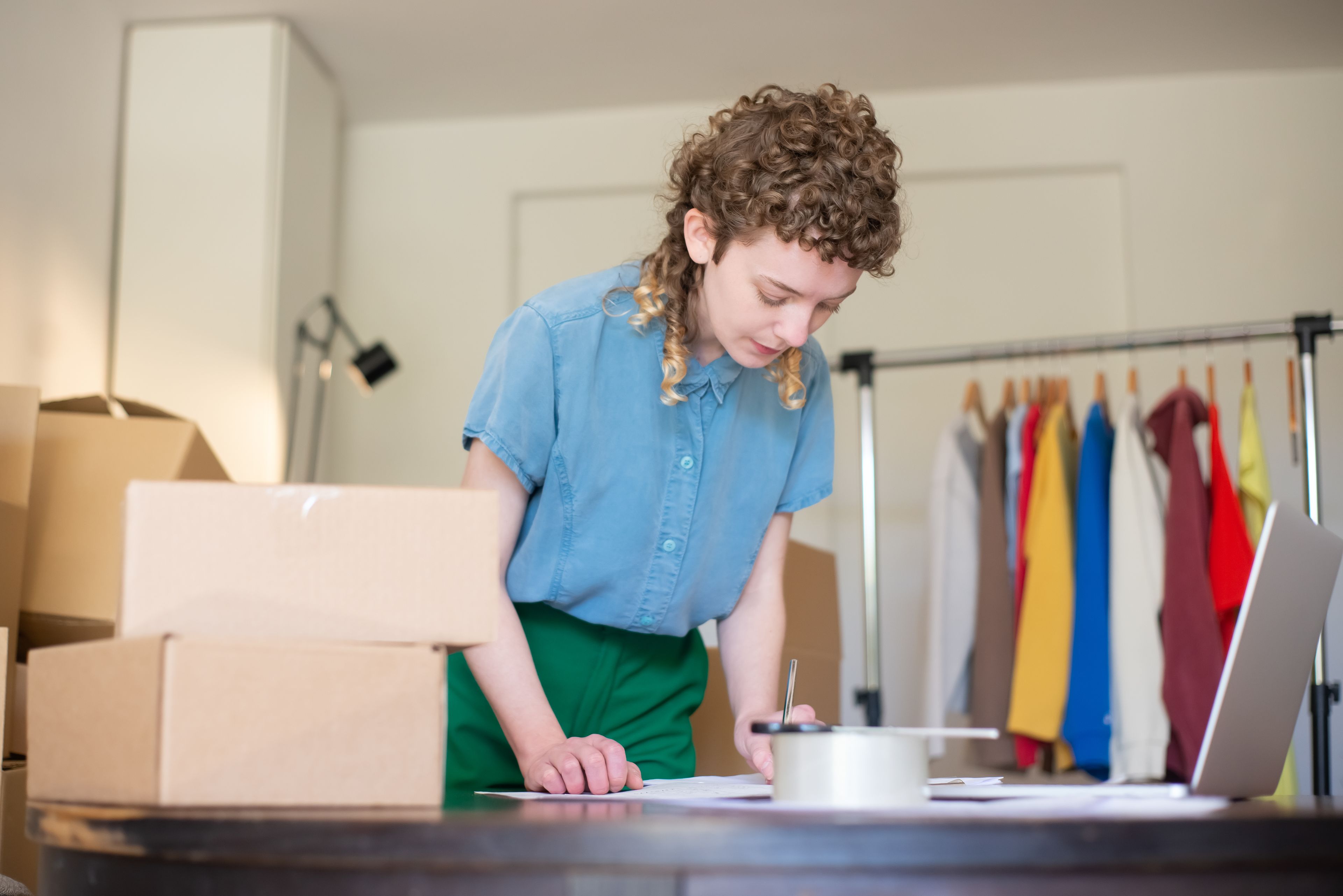 A shop owner writing her weekly update between packed orders