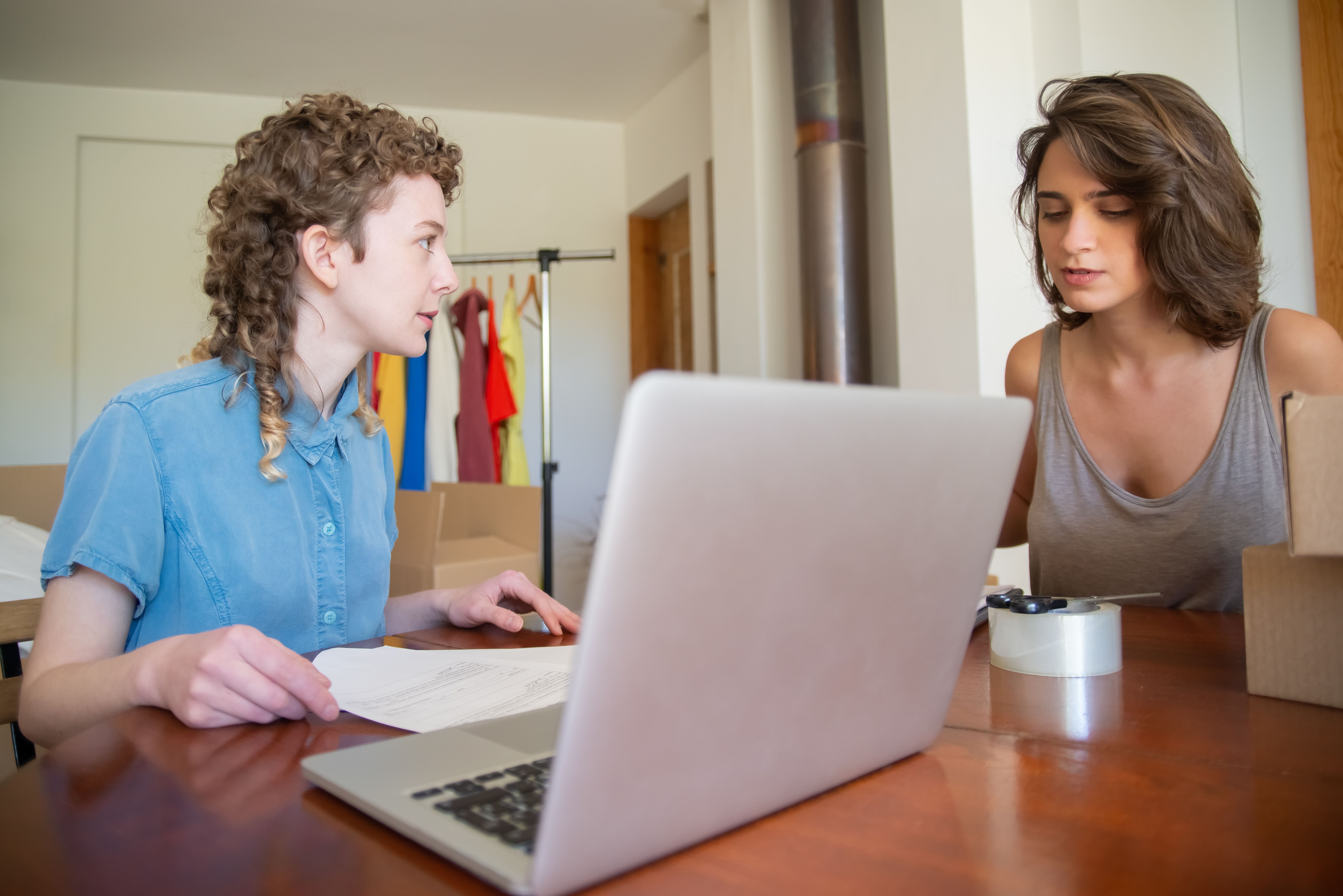 Two women working together at a desk in a modern home office setting.