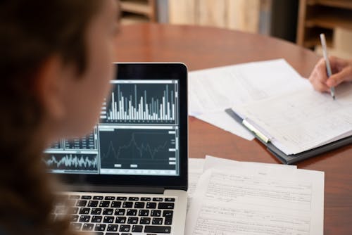 Laptop and Papers of Employees During a Meeting