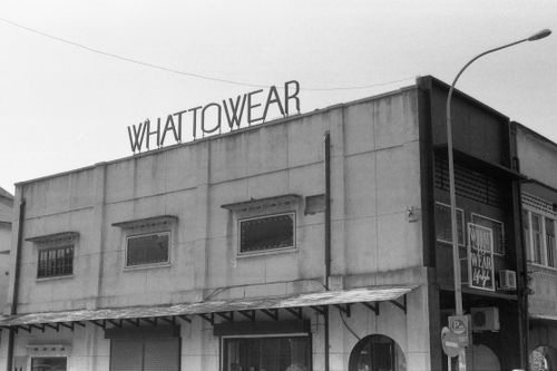 Free Monochrome image of a building with 'Whattowear' sign in urban setting. Stock Photo