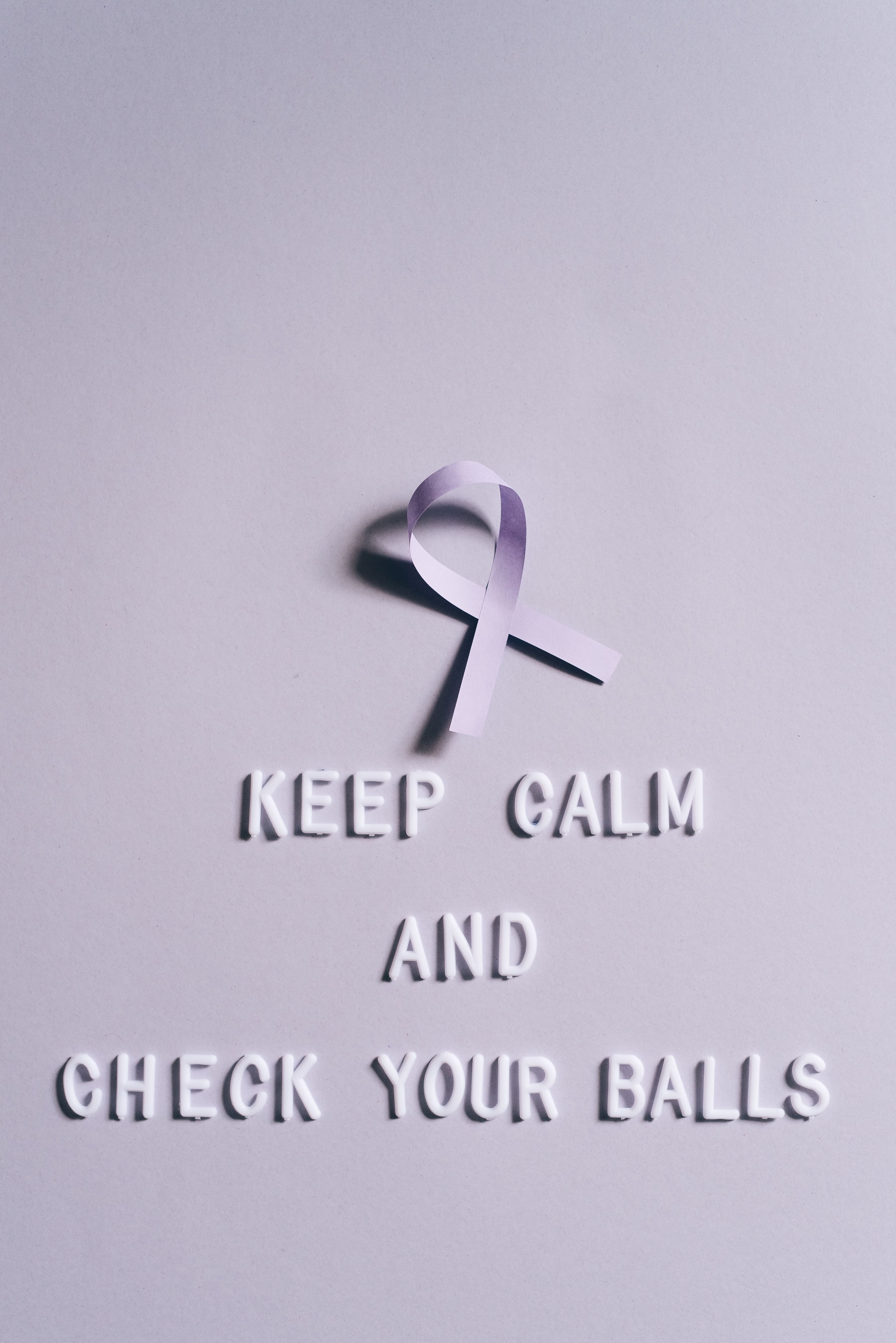 Light pink ribbon on a light background with quote for testicular cancer awareness.