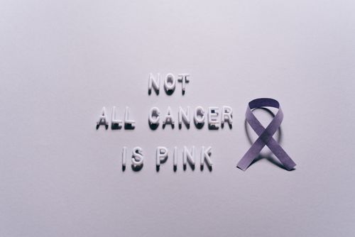 Free Purple ribbon with 'Not All Cancer is Pink' text symbolizing awareness for various cancer types. Stock Photo