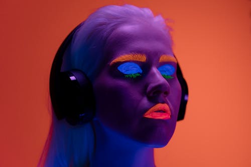A Woman with Luminous Lipstick and Eye Shadow Wearing Headphones