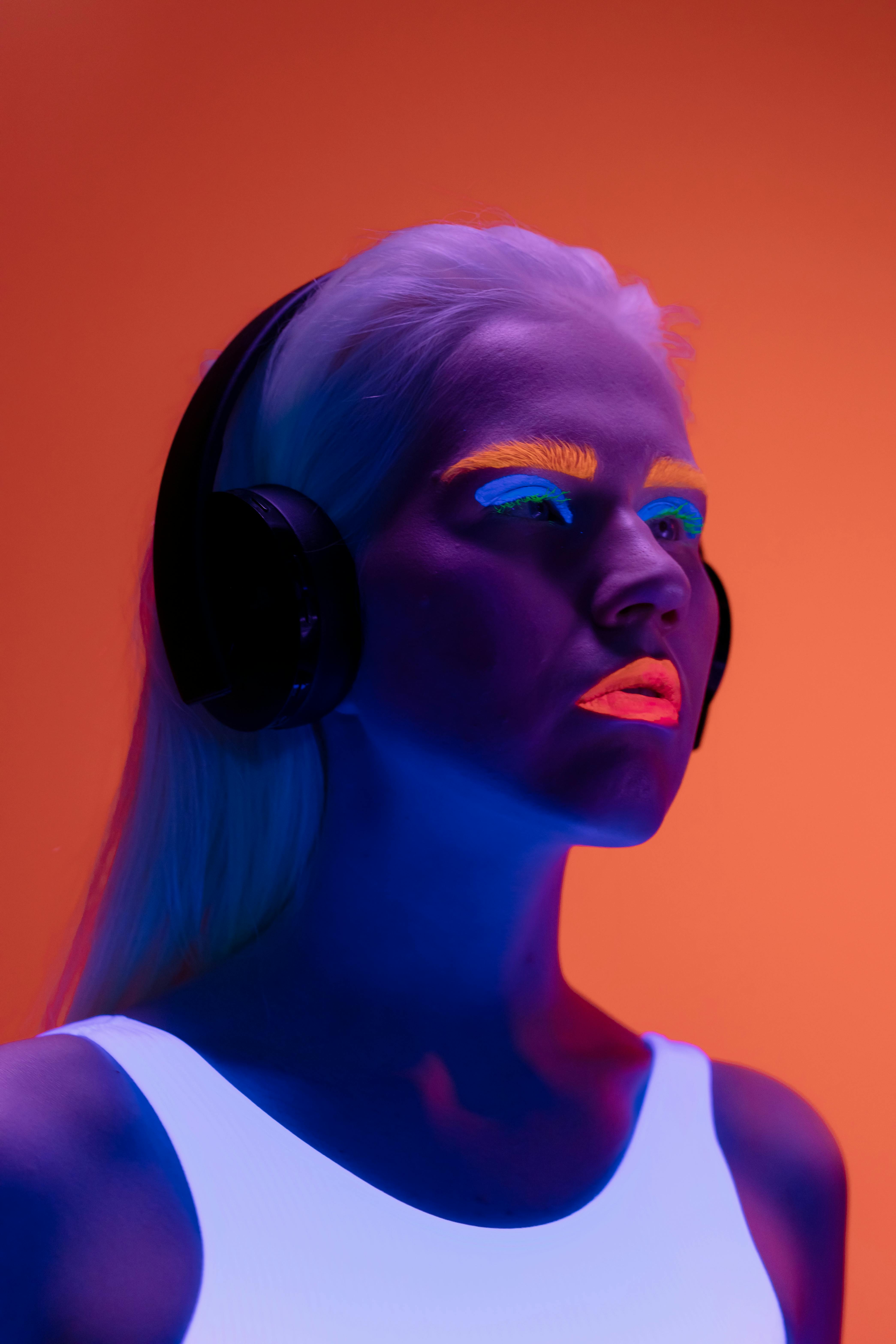 woman with neon make up wearing black headphones