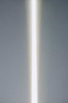 Abstract image of a vertical light streak on a gray background, perfect for wallpapers.