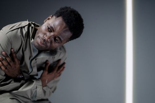 Free Portrait of a man in a thoughtful pose with cross arms in a studio setting, offering copy space. Stock Photo