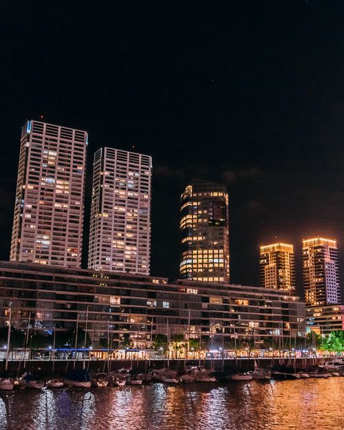 Free Captivating night view of Buenos Aires skyline with illuminated high-rises by the river. Stock Photo