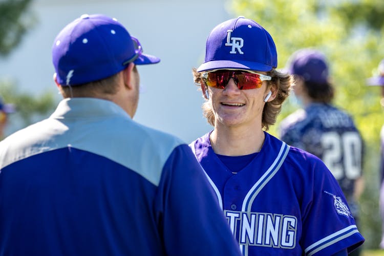 Man In Blue Jersey And Blue Cap Wearing Sunglasses