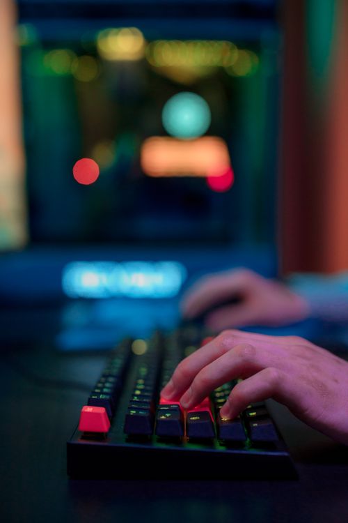 Osoba tipka na tastaturi noću uz osvijetljenu tipkovnicu