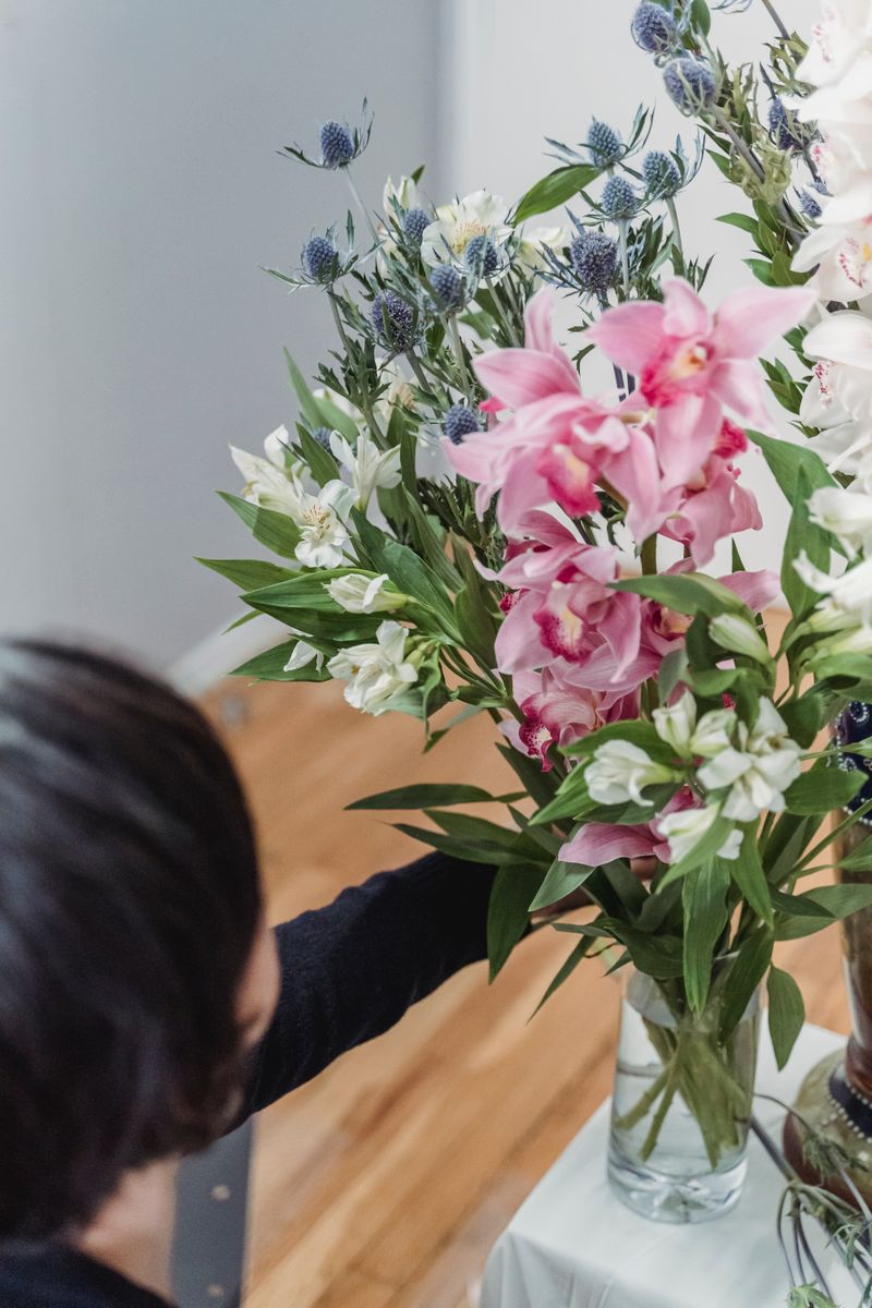 Hand arranging crochet flowers in a vase