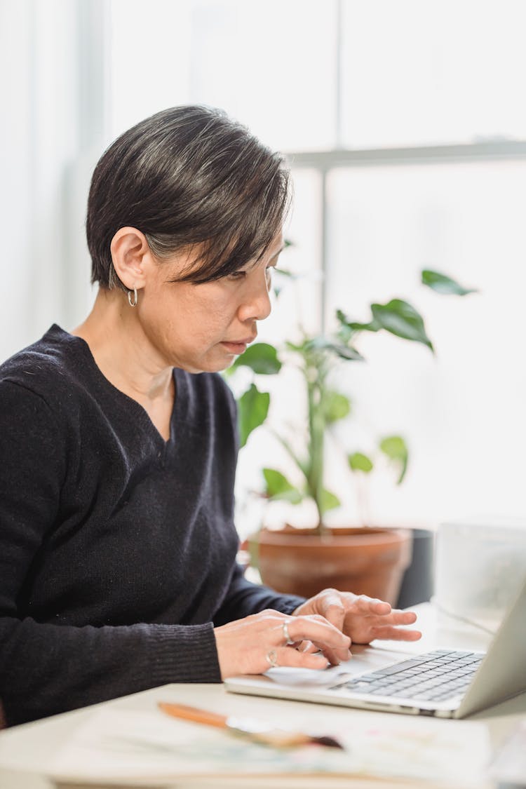 Woman Browsing The Internet By Using A Laptop