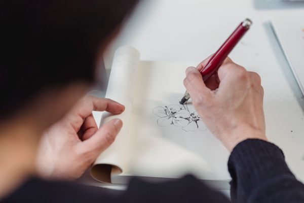 Hand drawing a floral study in ink — photo by Greta Hoffman on Pexels