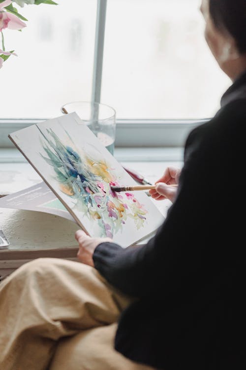 A Woman Painting an Artwork in a Sketchpad