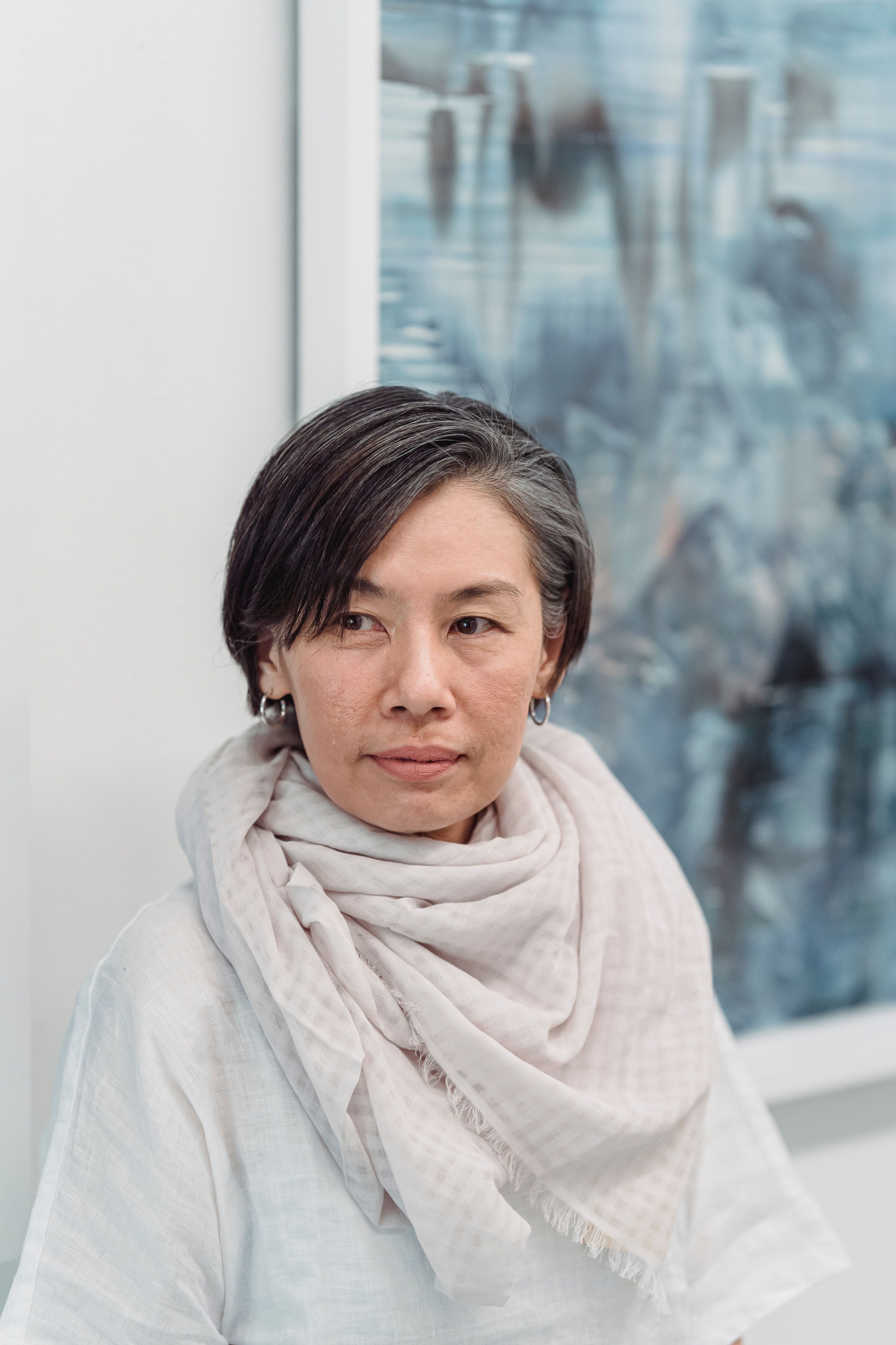 A serene portrait of a middle-aged woman in a soft scarf, exuding calm and confidence.