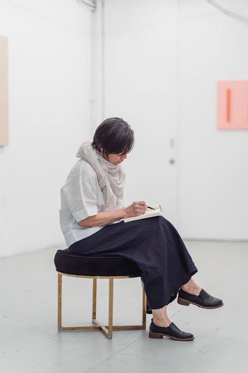 Женщина, сидящая на стуле, рисует произведение искусства