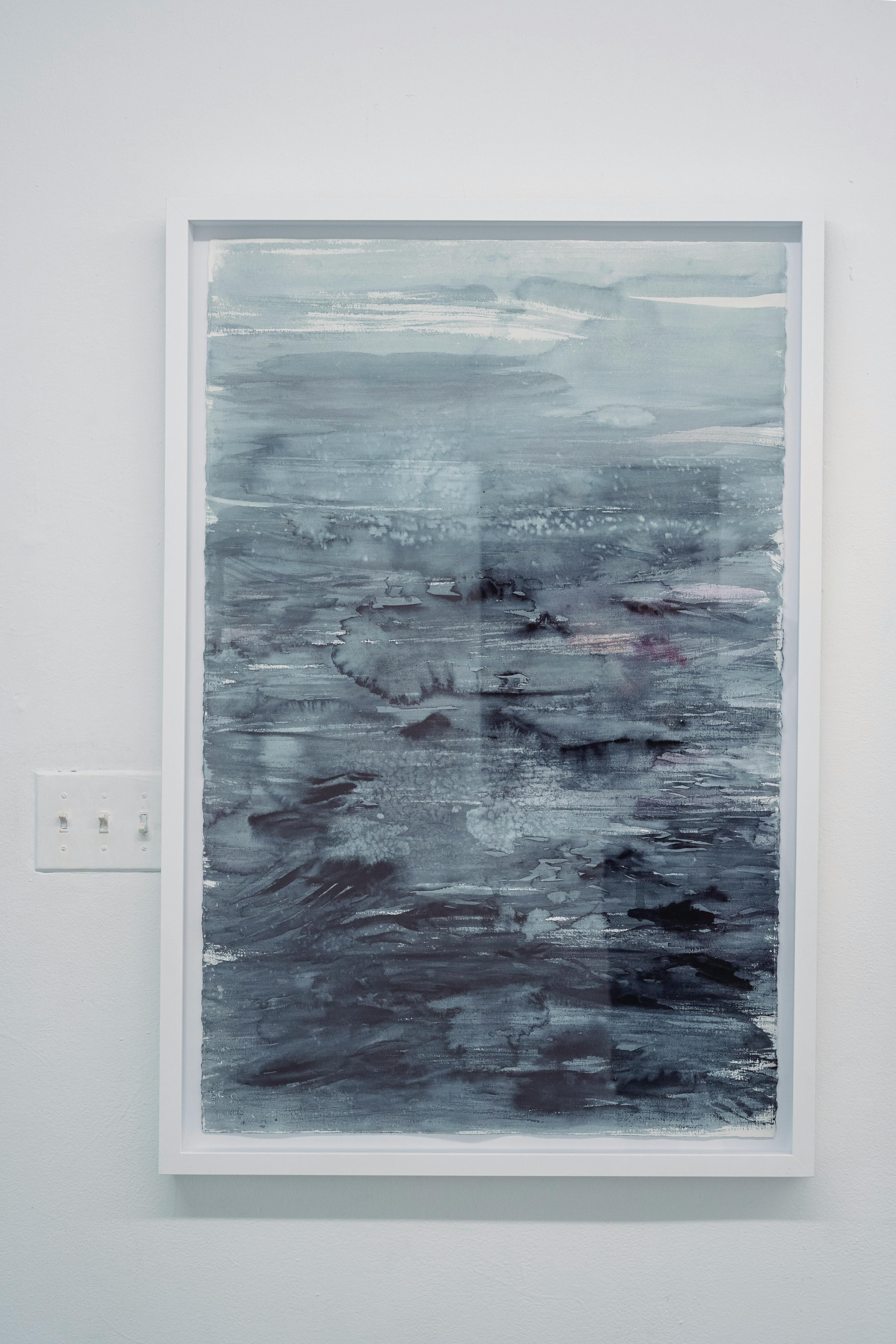 蓝色色调的垂直抽象绘画，以海景为主题，框架在白色的墙上