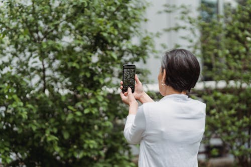Free Woman Taking Photos Using Her Smartphone Stock Photo