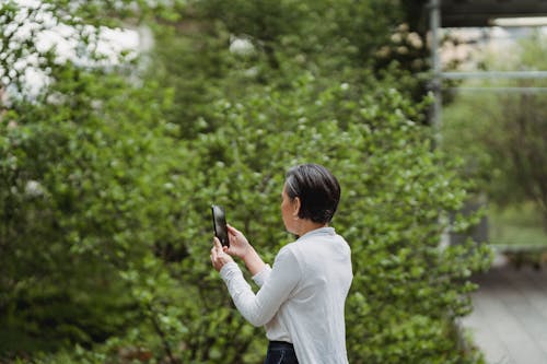 Free Woman Taking Photos Using Her Smartphone Stock Photo