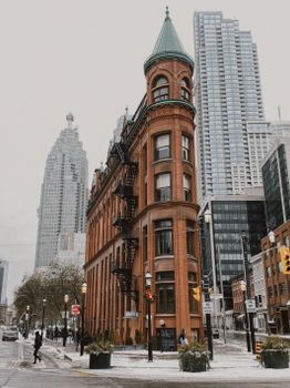 Iconic Gooderham Building in Toronto against modern skyscrapers, showcasing architectural contrast.