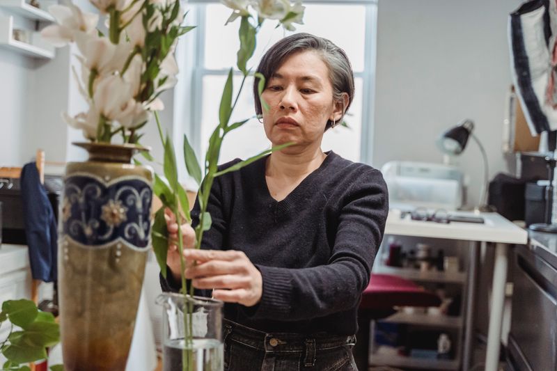 Florist placing a fresh seasonal arrangement in a Charleston office reception area