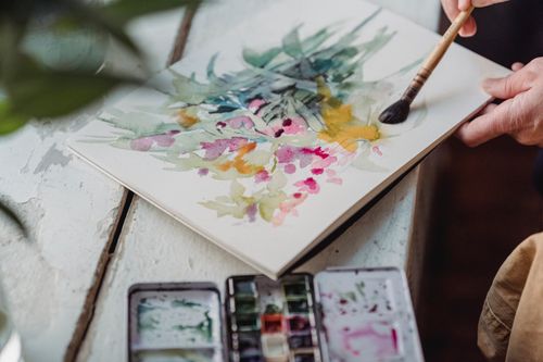 Free Close-up of a vibrant watercolor painting in progress with a paintbrush. Stock Photo