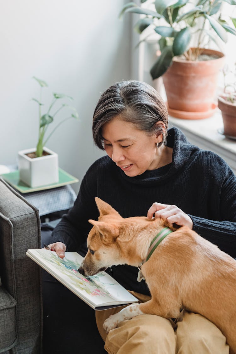 Woman And Dog Looking At An Artwork Painted In A Sketchpad