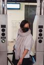 A Woman Passes Through a Turnstile at a Train Station