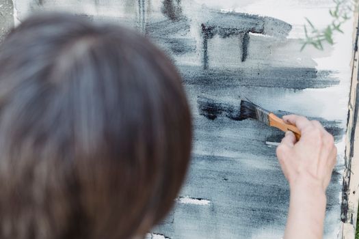 Close-up of a person painting abstract brushstrokes on canvas, showcasing artistic creativity.